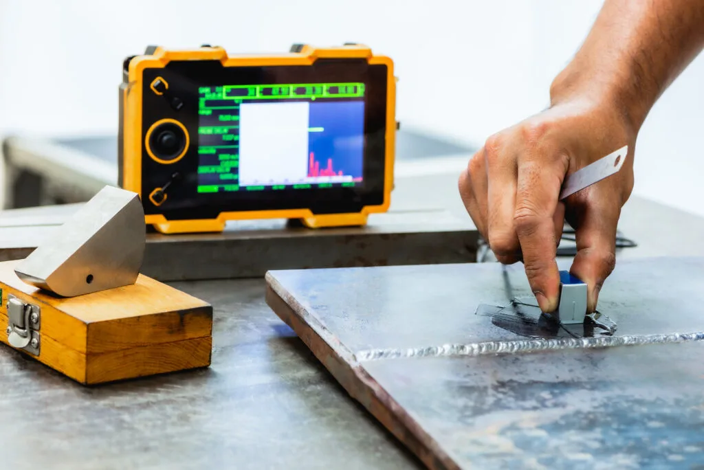 Technician performing non-destructive testing on a steel component.